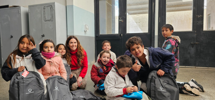 Jimena López junto a niños de escuela en Quequén.
